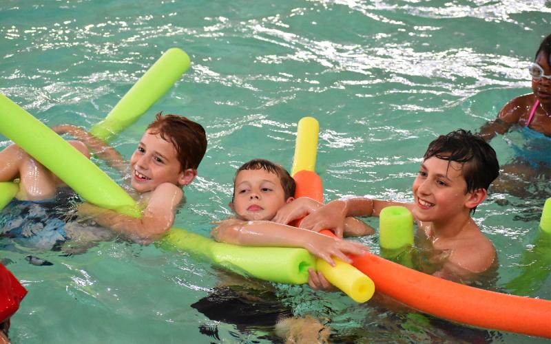 From left, Waylon Brookshire, Matthew Small and Drake Parker have fun floating on pool noodles at Camp Twisters Tuesday. ISAIAH SMITH/Staff