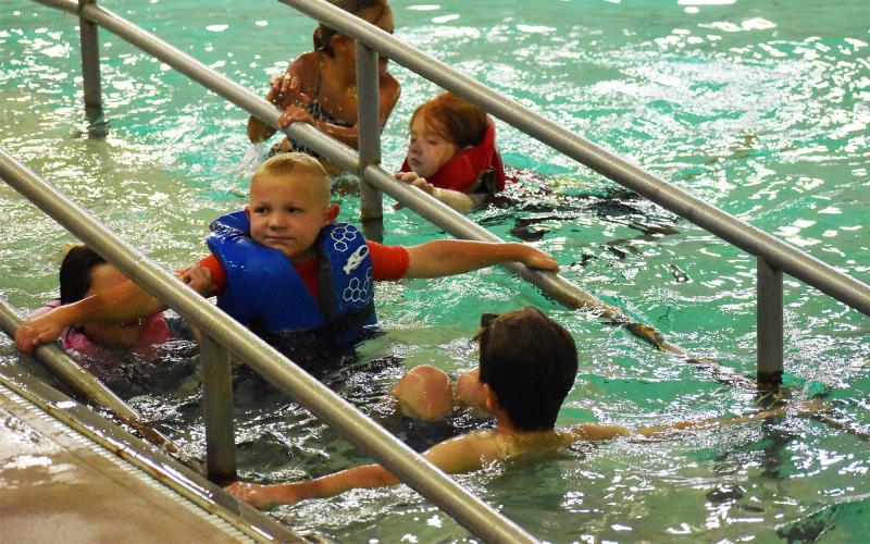 Ares Sprague wades down the ramp during a swim day at Camp Twisters.  ISAIAH SMITH/Staff