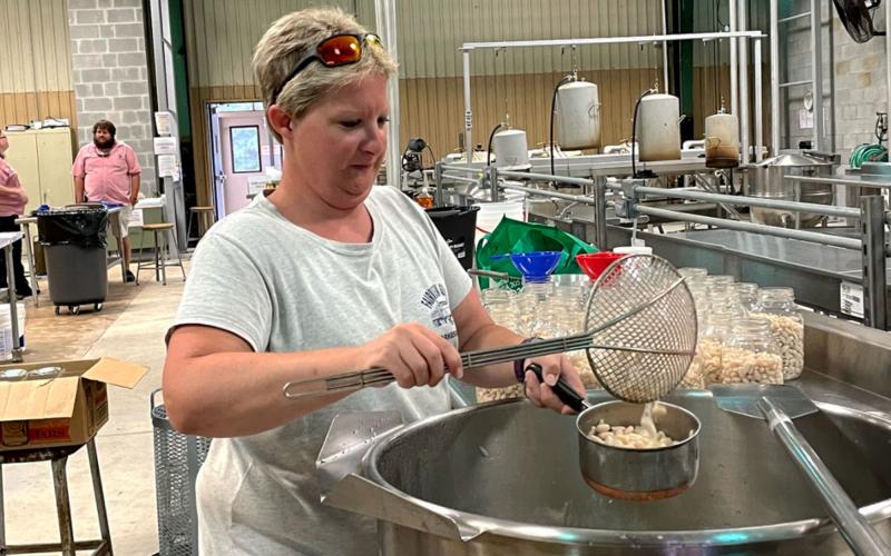 Christy Petitt works on canning Great Northern beans at the Habersham Canning Plant. BRIAN WELLMEIER/Staff