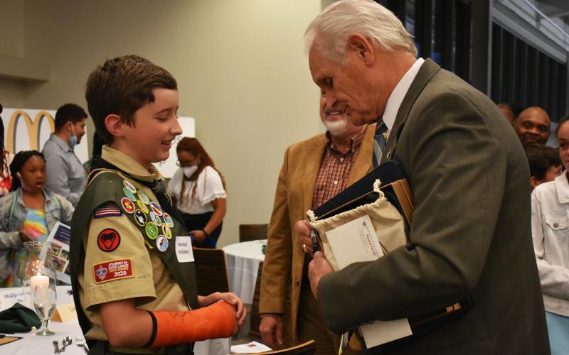 Mitchell McGahee, a member of Boy Scouts of America Troop 5 in Clarkesville, asks Darrel Chaney to sign his cast after the American Values Dinner on Thursday night. Chaney was a Major League Baseball player with the Cincinnati Reds from 1969-1975 and Atlanta Braves from 1976-1979. CHAMIAN CRUZ/Staff