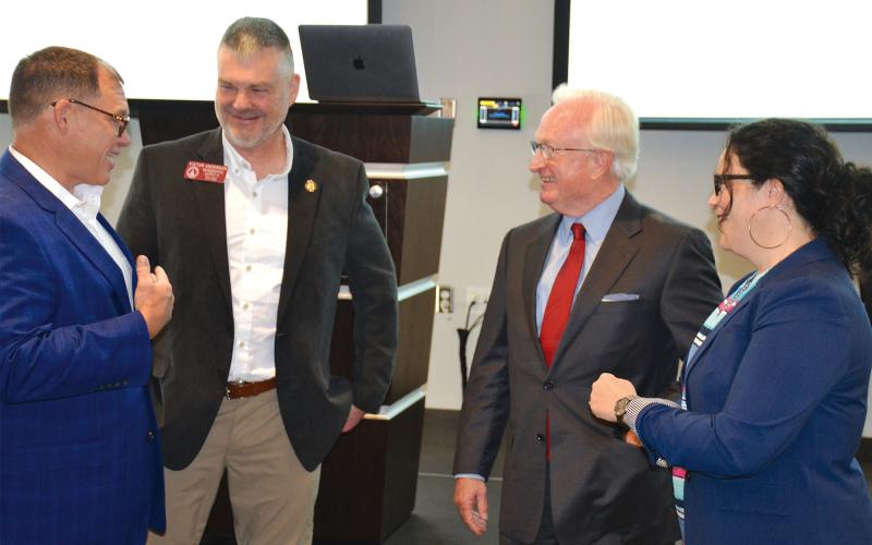 Outgoing County Manager Phil Sutton (second from right) talks with former county commissioners (from left) Stacy Hall, Victor Anderson and Natalie Crawford at Wednesday’s Partnership Habersham meeting, where Sutton was honored by local leaders. MATTHEW OSBORNE/Staff