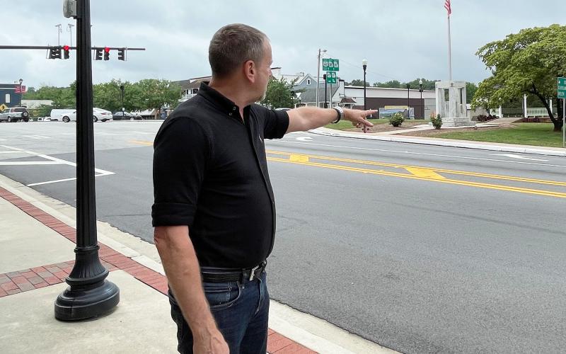 Lew Oliver gestures toward the square he plans to redevelop in downtown Clarkesville. BRIAN WELLMEIER/Staff