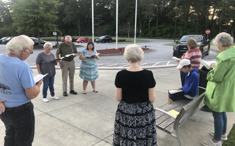 Gathered residents from various churches read from the Book of Luke early Wednesday morning in Clarkesville. MATTHEW OSBORNE/Staff