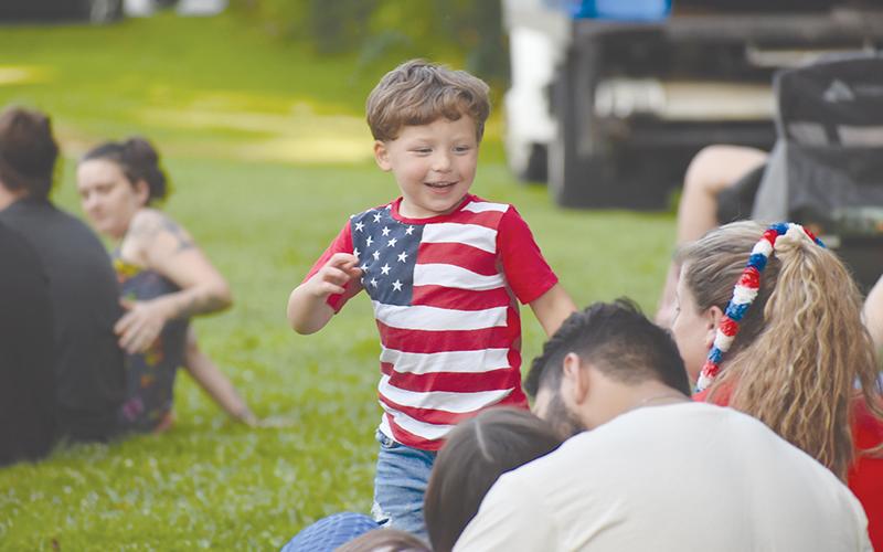 Jordan White danced happily to the music and donned a friend with a patriotic necklace.