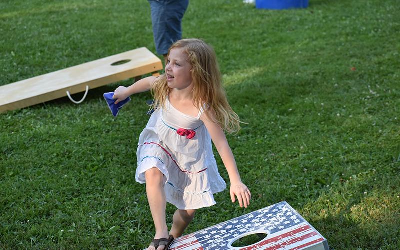 Isabella Cangiolosi tries out the all-American pastime of cornhole at the Demorest Glorious Fourth event Sunday.
