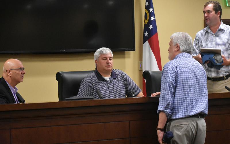 Habersham County Airport commissioners Lawrence Bridges, D. Higgins, Ken Schubring and Chris Limbach talk amongst each other after the meeting Monday morning. CHAMIAN CRUZ/Staff