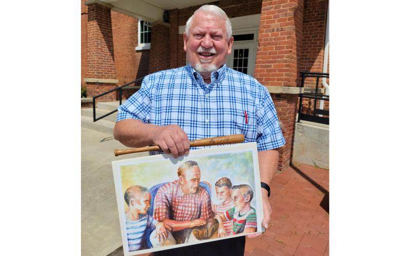 Mt. Airy Mayor Gary Morris shows off a bat Ty Cobb gave him along with a painting of Cobb and Habersham County youths (from left) Jimmy Powell, Morris and Sam Tolbert done by Greg Kimsey in 2002. ALAN NESMITH/Staff