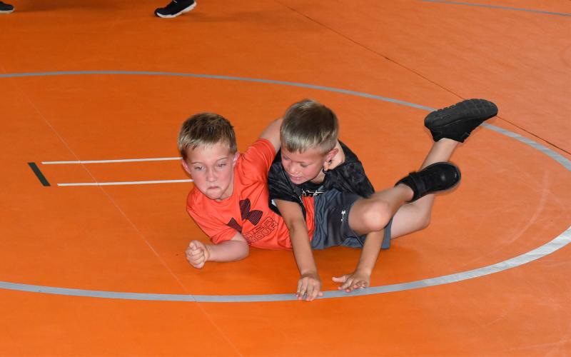 Chasten Roberts (red shirt) gets work in with Garrett Tacto during Raider wrestling camp. MATTHEW OSBORNE/Staff