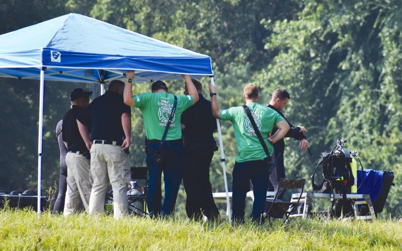 A diver from the Georgia State Patrol puts on his underwater gear shortly before first responders found the body of Mark Hicks on Monday morning. MATTHEW OSBORNE/Staff