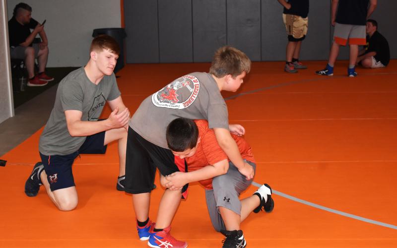 Habersham Central wrestler Colby Watson helps instruct Seth Vandiver (bottom) and Hudson Henderson. MATTHEW OSBORNE/Staff