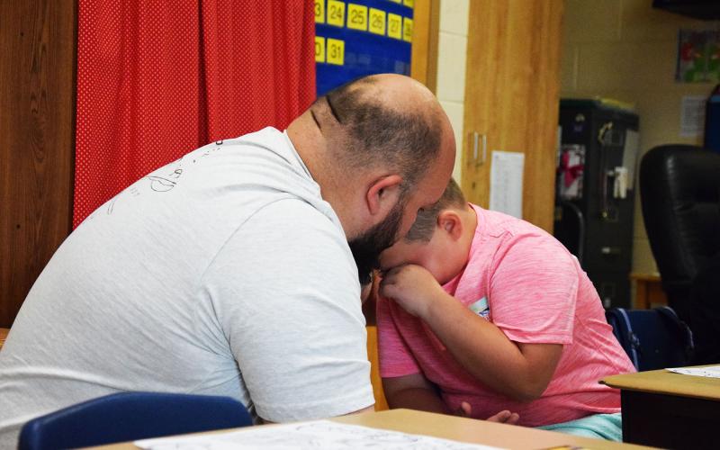 Clarkesville Elementary first grader Landen Thompson seeks comfort from dad Brandon Thompson before the first day of school begins. SAMANTHA SINCLAIR/CNI News Service