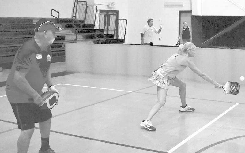 Sonja Defoor returns a shot while partner Dennis Breedlove looks to help with the next return. BRYANT ROCHE/Staff