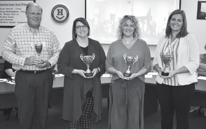 Principals Rodney Long of Baldwin Elementary, Dr. Connie Franklin of the Ninth Grade Academy, Marybeth Thomas of Wilbanks Middle School and Aimee Shedd of Hazel Grove Elementary accept their attendance awards for August at Monday’s Board of Education meeting. MATTHEW OSBORNE/Staff