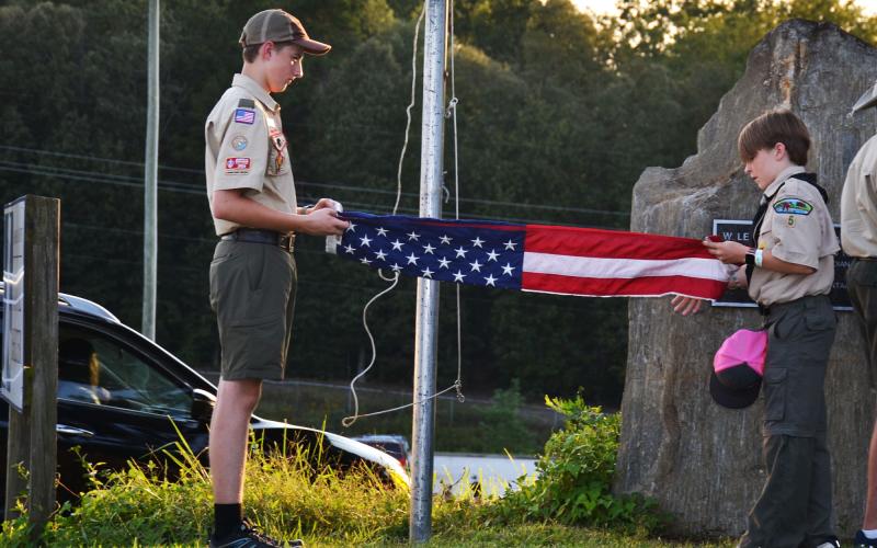 Boy Scouts Joseph McGahee and Thatcher Tatum unfold the American flag before the fair begins Friday night. BRIAN WELLMEIER/Staff