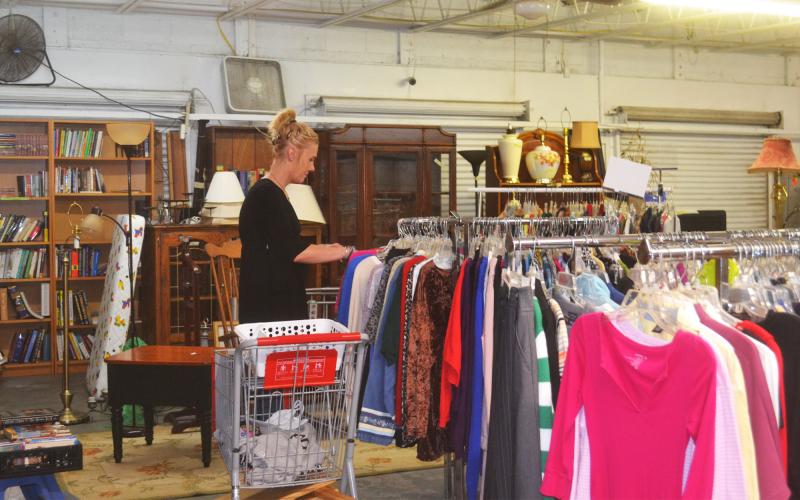 Manager Jessie Dennis sorts clothing at the Circle of Hope thrift store. BRIAN WELLMEIER/Staff