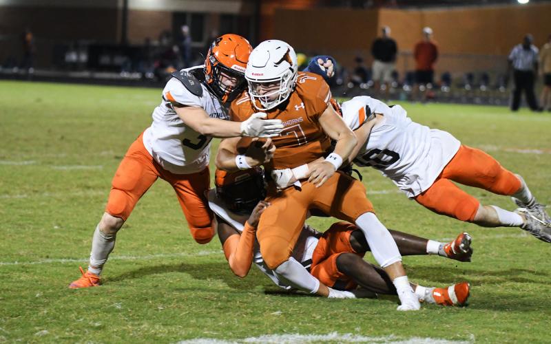 Habersham Central’s Braydon Wright (left) and Noah Wilson lead a pile of Raiders tackling  Lanier quarterback Carson  Thomas during Friday’s game in Sugar Hill. TOM ASKEW/Special