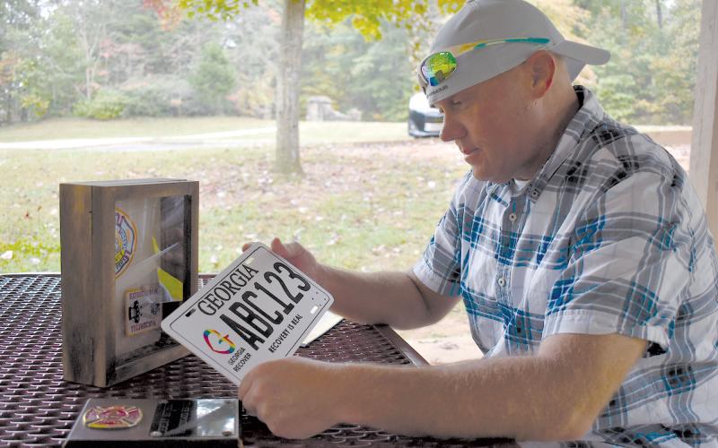 Jeremy Mitchell reflects on his time spent as a firefighter before running afoul of drugs and getting off track. The license plate was given for successful completion of drug court. MATTHEW OSBORNE/Staff