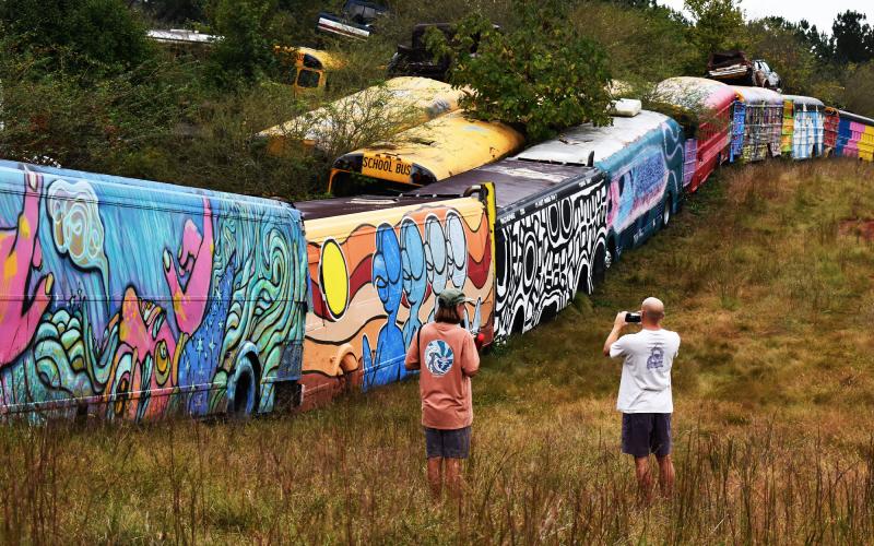 Tourists from North Carolina check out the school bus graveyard in Alto on Tuesday morning. MATTHEW OSBORNE/Staff