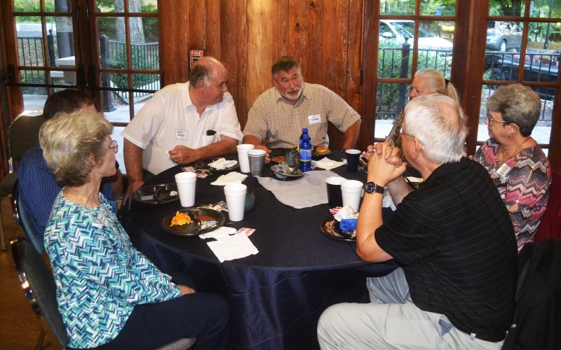 Andy Kitchens shares a story with classmates Lela Harrison Whelchel, Calvin Meeks, Raymond Payne and their spouses at the Habersham Central 50th reunion. MATTHEW OSBORNE/Staff
