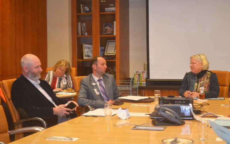 Habersham Medical Center CEO Tyler Williams (middle) talks with Hospital Authority members Dr. Joshua Garrett (left) and Chair Dolly Ritchie (right) during Tuesday’s meeting. BRIAN WELLMEIER/Staff
