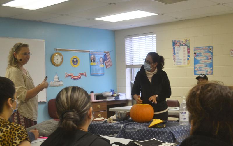 North Georgia Technical College’s ESL Director Michelle Wilson invites English learners to carve a pumpkin at First Baptist Church in Cornelia. BRIAN WELLMEIER/Staff