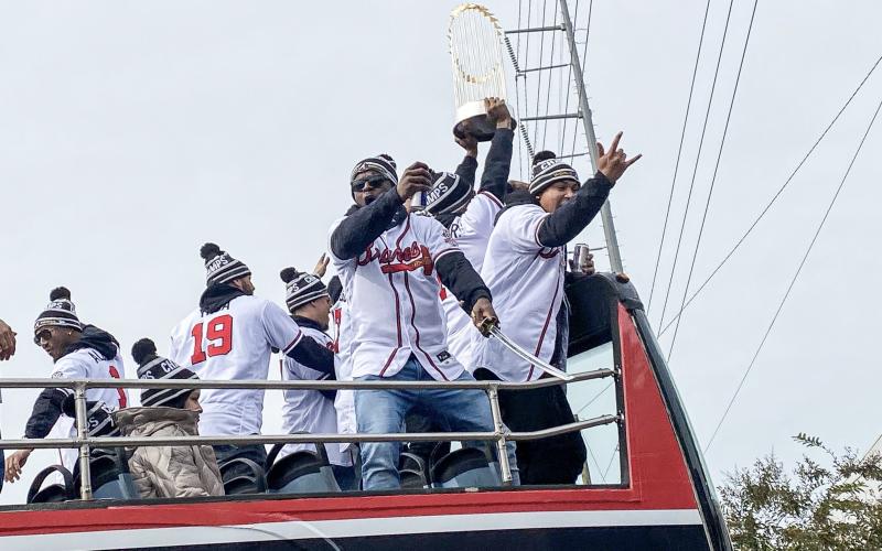 With a beer in one hand and a samurai sword in the other, Guillermo Heredia celebrates with his teammates during the Braves’ World Series Champion Parade on Friday, Nov. 5. Also pictured are players Ozzie Albies, Huascar Ynoa, William Contreras, Roñald Acuna Jr. and Orlando Arcia. CODY ROGERS/Staff