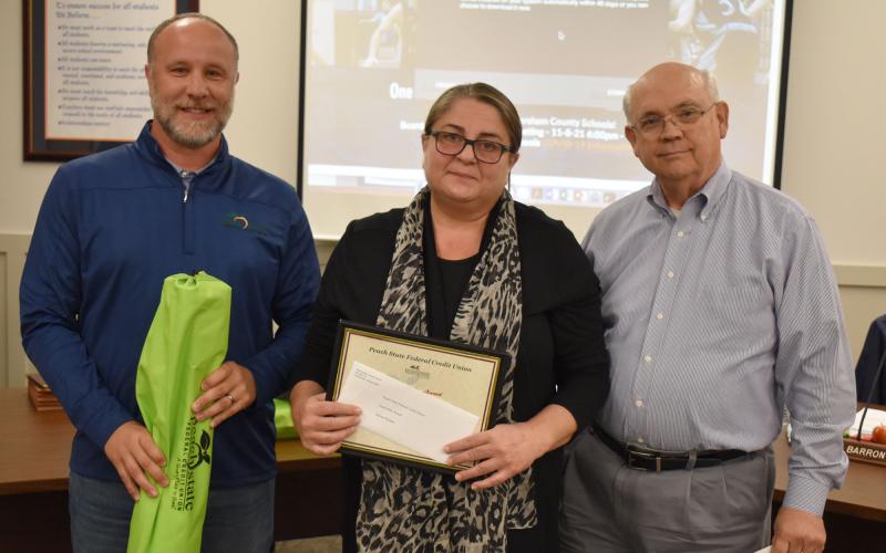 Gulnur Pendaz accepted the Extra Mile Award from Peach State Credit Union’s Scott Roland and school board member Dr. Robert Barron. MATTHEW OSBORNE/Staff