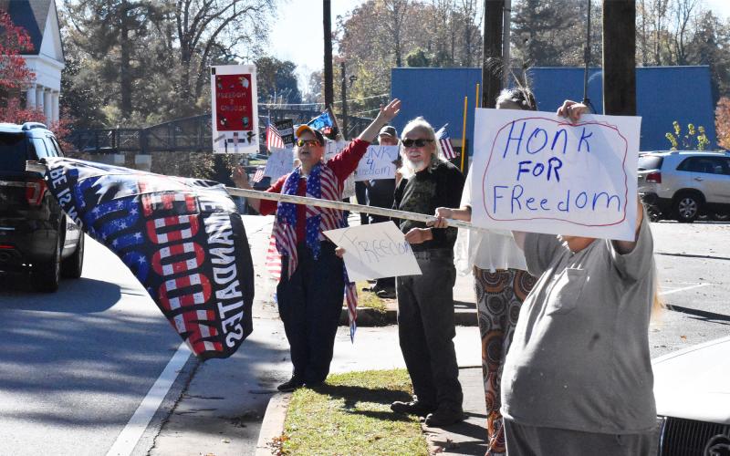 Protestors on the campus of Piedmont University ask drivers on Historic Highway 441 to honk in support of their opposition to vaccine mandates Wednesday afternoon. MATTHEW OSBORNE/Staff