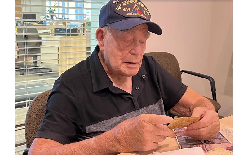James Ramey sifts through memories gathered from his service in World War II. Ramey is looking at his day pass from Camp Hood, Texas, one of many places he trained before heading overseas in 1944. MATTHEW OSBORNE/Staff