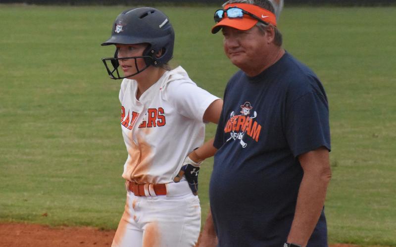 Coach Bill Bradley meets with Bailey Barfield after she reached base during a Lady Raiders 2021 home game. CODY ROGERS/Staff