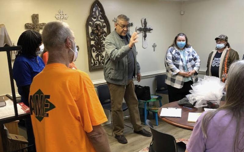Pastor Sam Negron prays with clients at Grace Gate Clinic. CAROL JOHNSON/Submitted