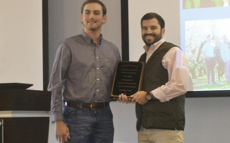 Jake Tench receives the Young Farmer and Rancher Excellence in Agriculture award from Farm Bureau’s Gilbert Barrett. BRIAN WELLMEIER/Staff