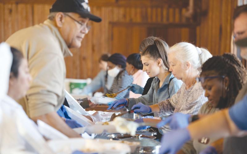 Savannah Bethea (middle left) and Louann Duckett (middle right) were among many volunteers serving up hot meals at the Community House in Cornelia on Thanksgiving Day. TOM ASKEW/Special