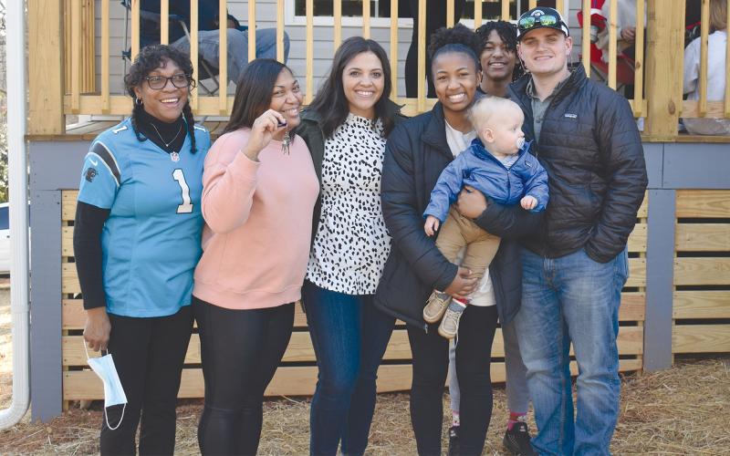 Lizzie Trimiar, Tinisha Combs, Kenly Gaddis, Emyrie Combs holding infant Shepp Gaddis, Enzo Combs (hiding in the back) and Bailey Gaddis take a moment in front of their new home. BRIAN WELLMEIER/Staff