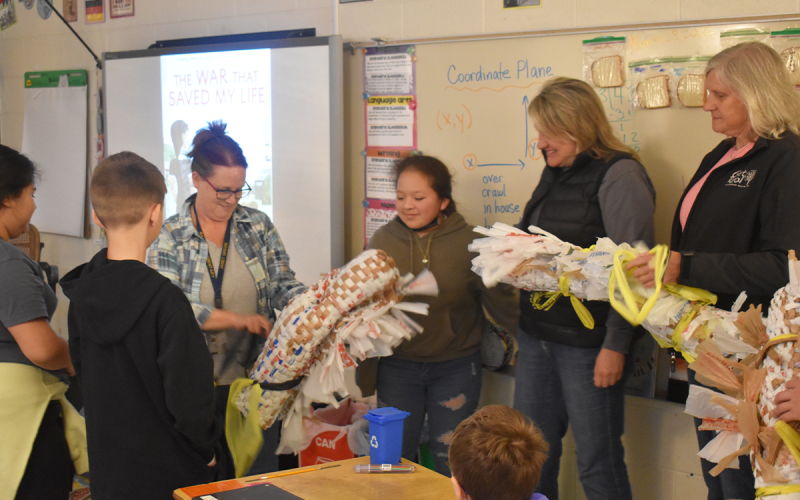 Janet Green unrolls the sleeping mats to show Get Real volunteers Jennifer Hart and Kelly McDuffie what her fifth grade class made. AMARIS E. RODRIGUEZ/Staff