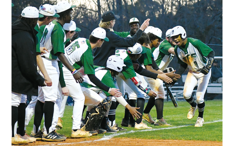 Malique Charlton runs through the line of low-fives before touching home plate. He hit one of the many TFS home runs in their win over region rival George Walton last Thursday. CODY ROGERS/Staff