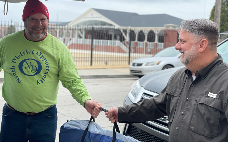 Mike Fisher accepts donations of tents and sleeping bags from Jamey Prickett of Gainesville First United Methodist Church. LARA MOORE/Submitted