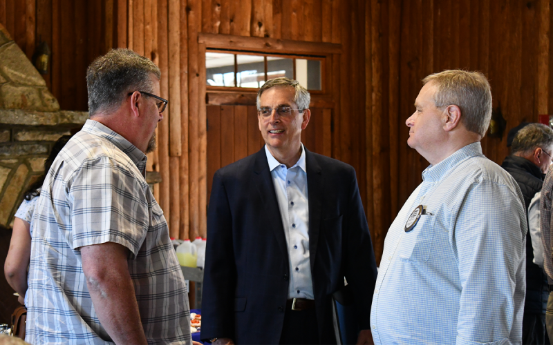 Duane Hartness (left) and Anthony Dalton (right) speak to Sec. Brad Raffensperger (middle) at the Community House on Thursday. BRIAN WELLMEIER/Staff