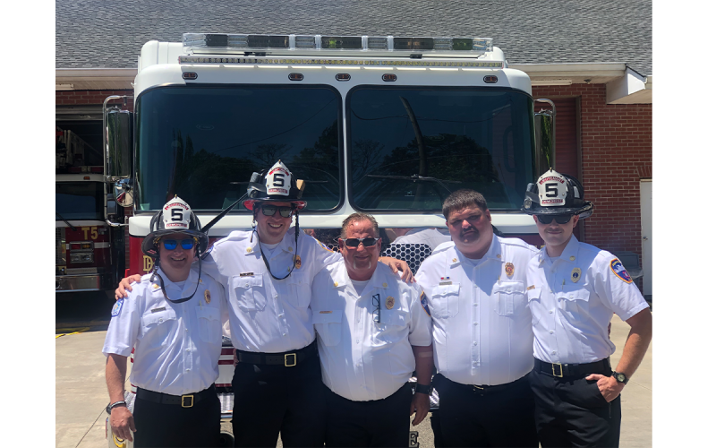Members of the Demorest Fire Department put their hands on their new fire truck Tuesday and rolled it back into the fire station to carry on a tradition established back when fire departments used wagons and horses. AMARIS E. RODGRIGUEZ/Staff