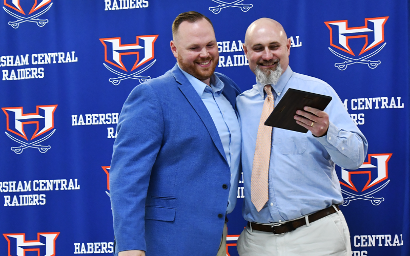 Gabe Irby admires his plaque with presenter Chris Warbington, who said he heard legends of a “mythical creature” coming out of eighth grade in the form of already 300-poiund Irby, who switched from tight end to tackle. MATTHEW OSBORNE/Staff