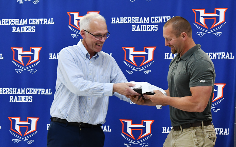 Coach Ken Ray presents Matt Roberts with his award for entering the Ring of Honor. Roberts was a two-time team MVP on a squad with at least seven Ring of Honor members on it. MATTHEW OSBORNE/Staff