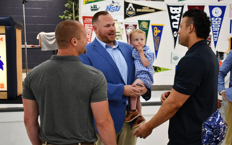 Ring of Honor Class of 2022 inductees (from left) Matt Roberts, Gabe Irby and Daniel Franklin catch up Thursday night before the banquet. Irby is holding his 22-month-old son Judah. MATTHEW OSBORNE/Staff
