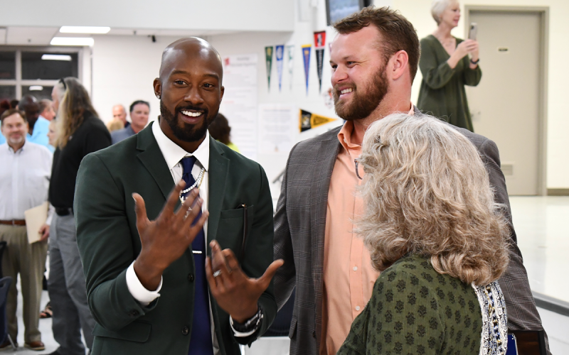 Former Raider passing partners Tavarres King (left) and Bo Hatchett chat with Martha  McManus after the banquet Thursday night. MATTHEW OSBORNE/Staff
