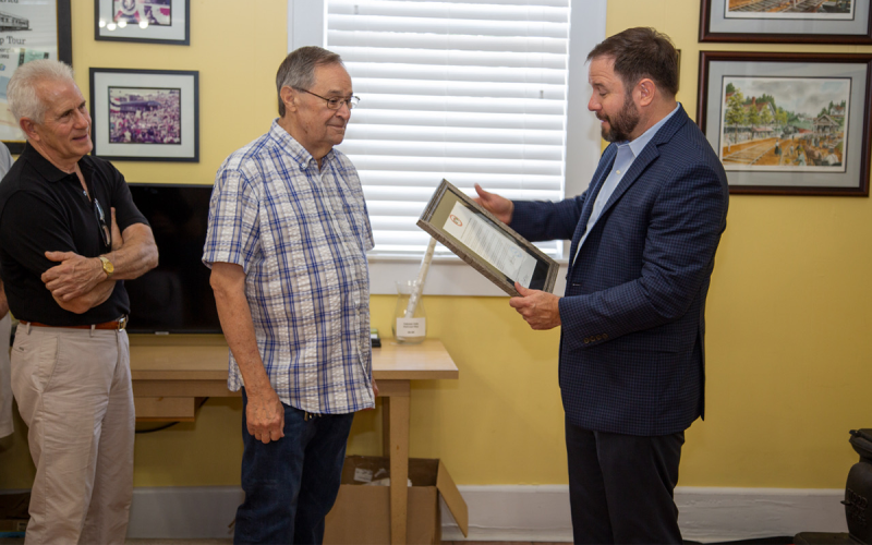 Buck Snyder humbly accepts a plaque from Cornelia Mayor John Borrow as Commissioner Don Bagwell (left) looks on at a ceremony Saturday morning. PETER MADRUGA/Submitted