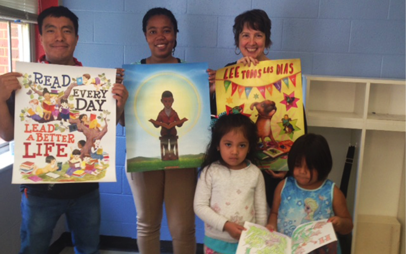 Former ELA students Diego Pascual and Manuela Fernando, along with instructor Charlise Rowley, show off posters showcasing the importance of literacy. SUBMITTED