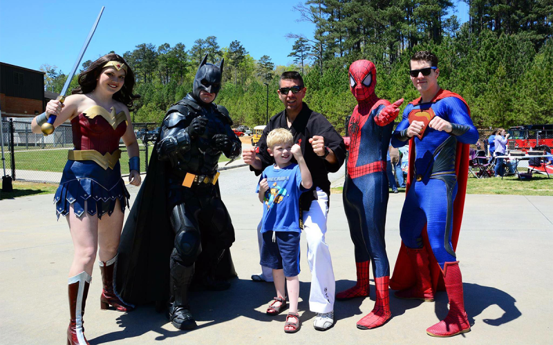 Wonder Woman (Judy Bellamy of Habersham County), Batman (Josh Brady of Stephens County), martial artist Todd Besier, Spider-Man (Jack Keane) and Superman (Matt Brady) take time to look heroic with a local youth. JOSH BRADY/Submitted