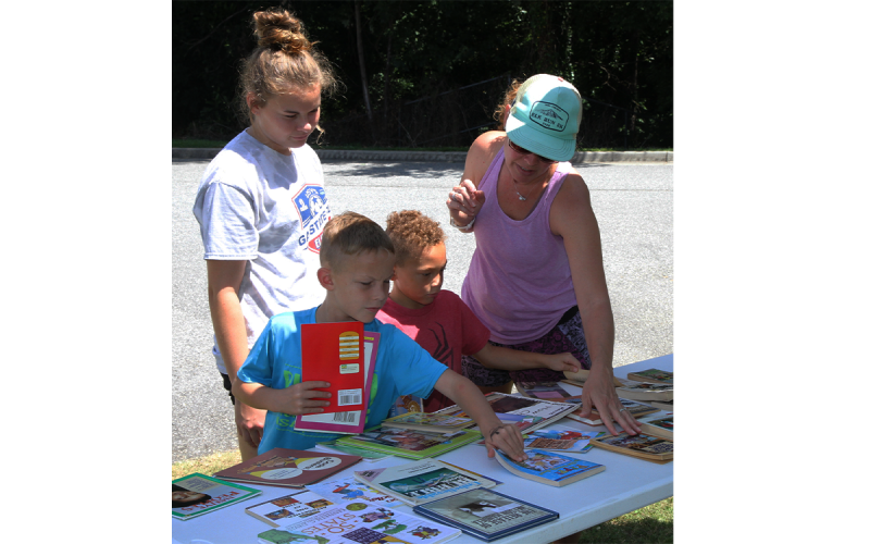 Shown from left, Jacob and Joseph Barnett get help choosing their five books from sister Hayden and mom Haley Barnett. PHYLECIA WILSON/Submitted