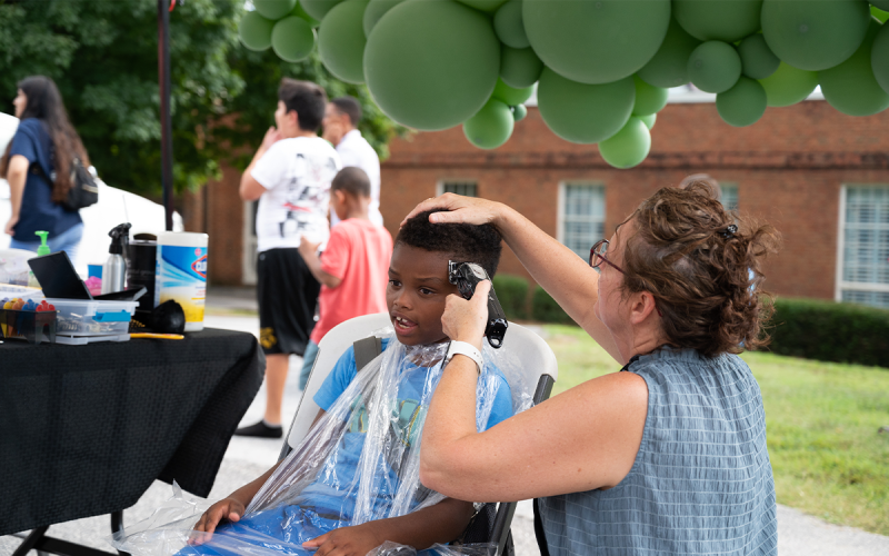 Cornelia United Methodist Church volunteer Penny McMahn provided free haircuts to many kids during the Back to School Block Party event, including Laquan Herz (left). ZACH TAYLOR/Special