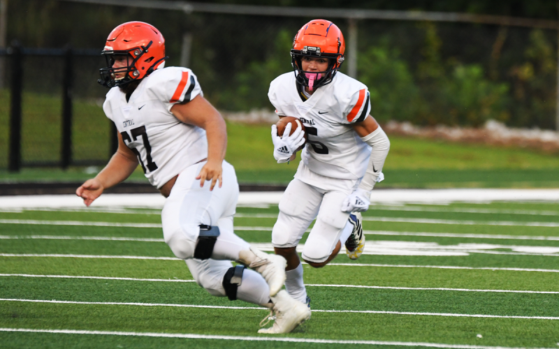 Zeke Whittington gets an escort from Thomas Dills during a first-quarter run Friday night. TOM ASKEW/Special