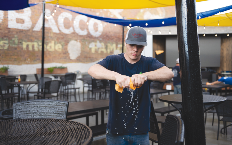 Albert Averhoff helps Fender’s employees dry off tables and chairs, and wrings out his rag afterward. ZACH TAYLOR/Special